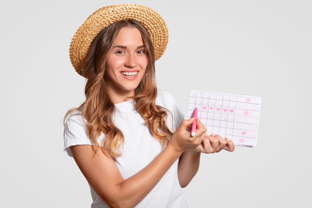 Mujer con un calendario señalando la fase folicular