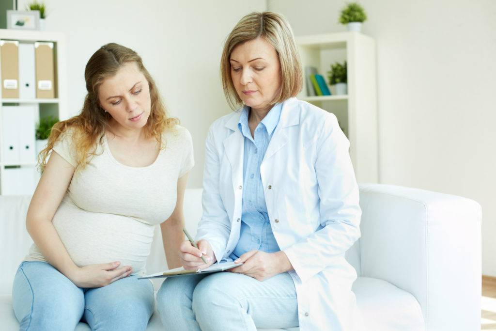 Mujer en consulta con su ginecóloga preguntándole porque hay embarazadas con regla