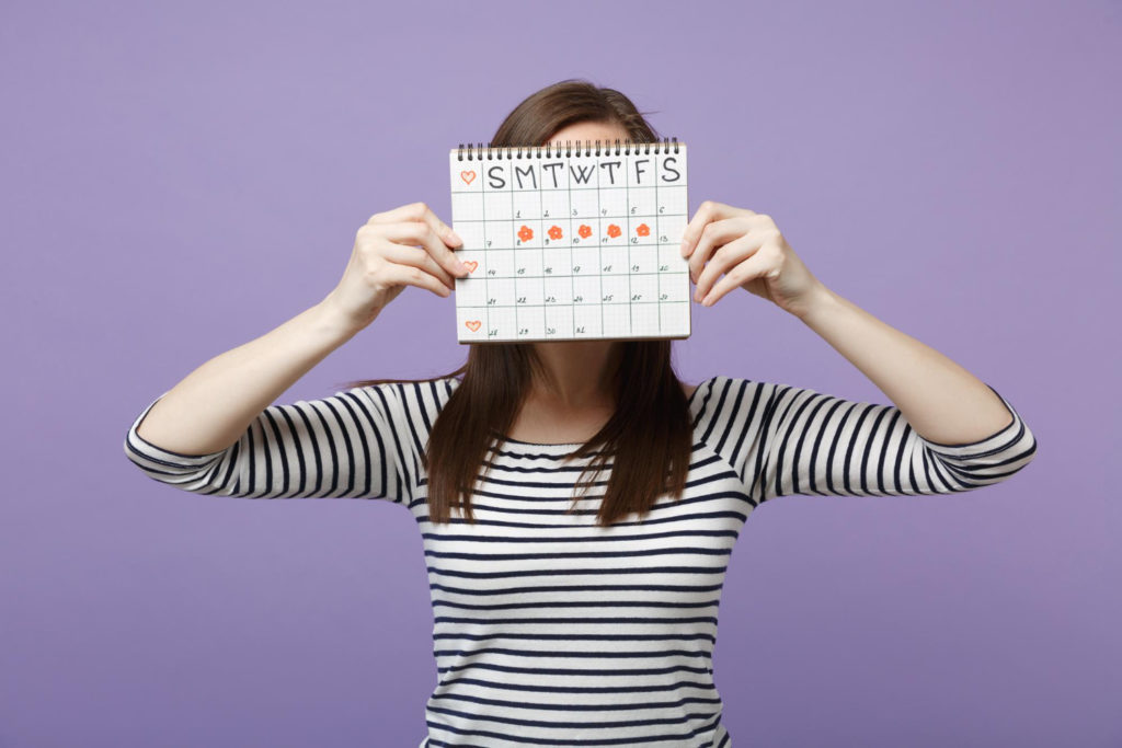 Mujer sujetando un calendario en el que se representa la fase lútea