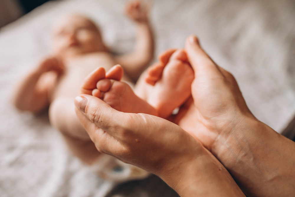 Mujer sosteniendo los pies de su bebé