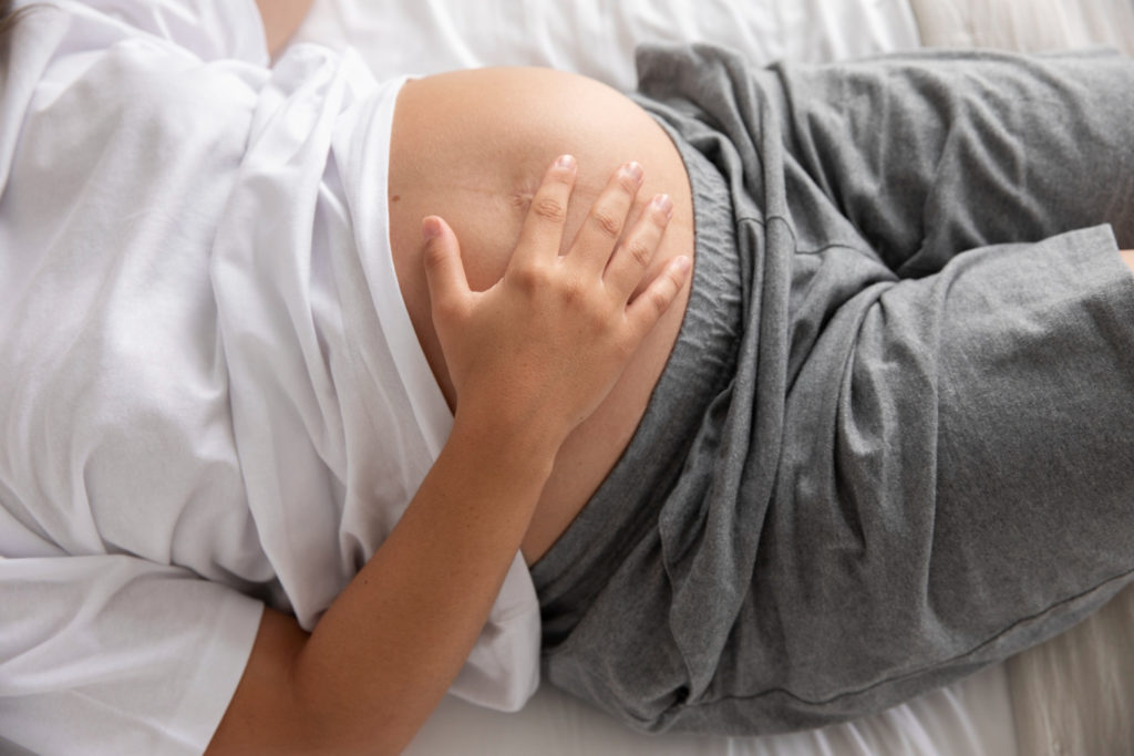 Mujer embarazada en la cama acostada con toxoplasmosis en el embarazo
