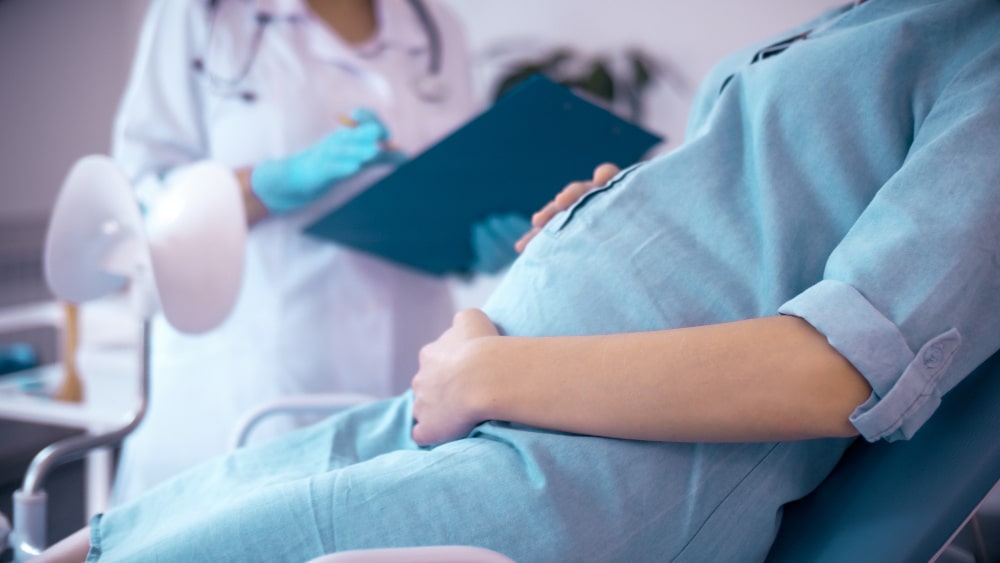 Mujer en el médico por tener fiebres en el embarazo