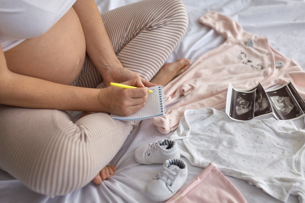 Mujer embarazada preparando la ropa de bebé