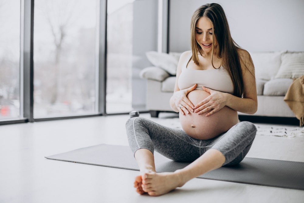 Mujer embarazada haciendo yoga para cuidar su microbioma