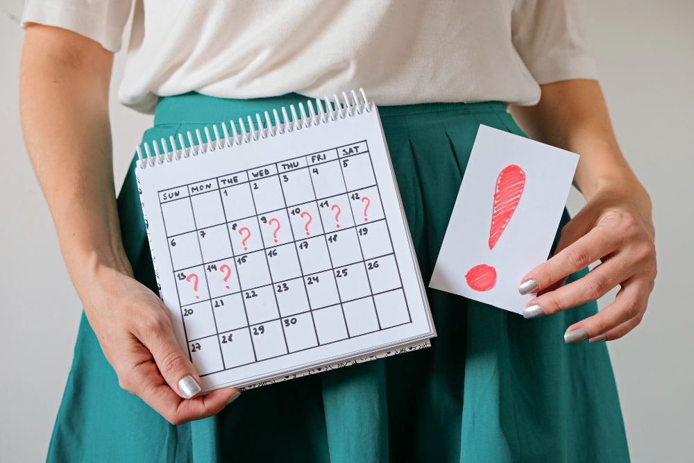 Mujer con calendario señalando los días imposibles para quedar embarazada