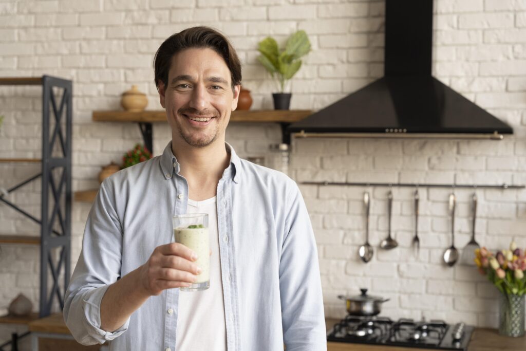 medium-shot-man-holding-smoothie-glass-min hombre batido