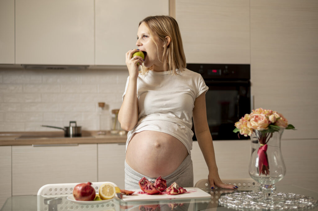 front-view-pregnant-woman-eating-apple Diabetes gestacional alimentos permitidos y prohibidos