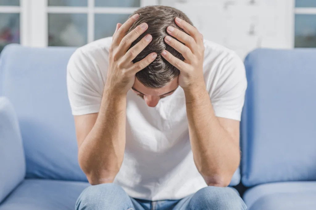 frustrated-man-suffering-from-headache-sitting-sofa-min Prolactina alta en hombres