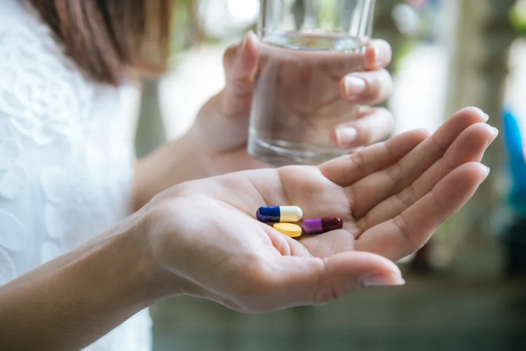 woman-s-hand-pours-medicine-pills-out-bottle-min Cómo bajar la prolactina