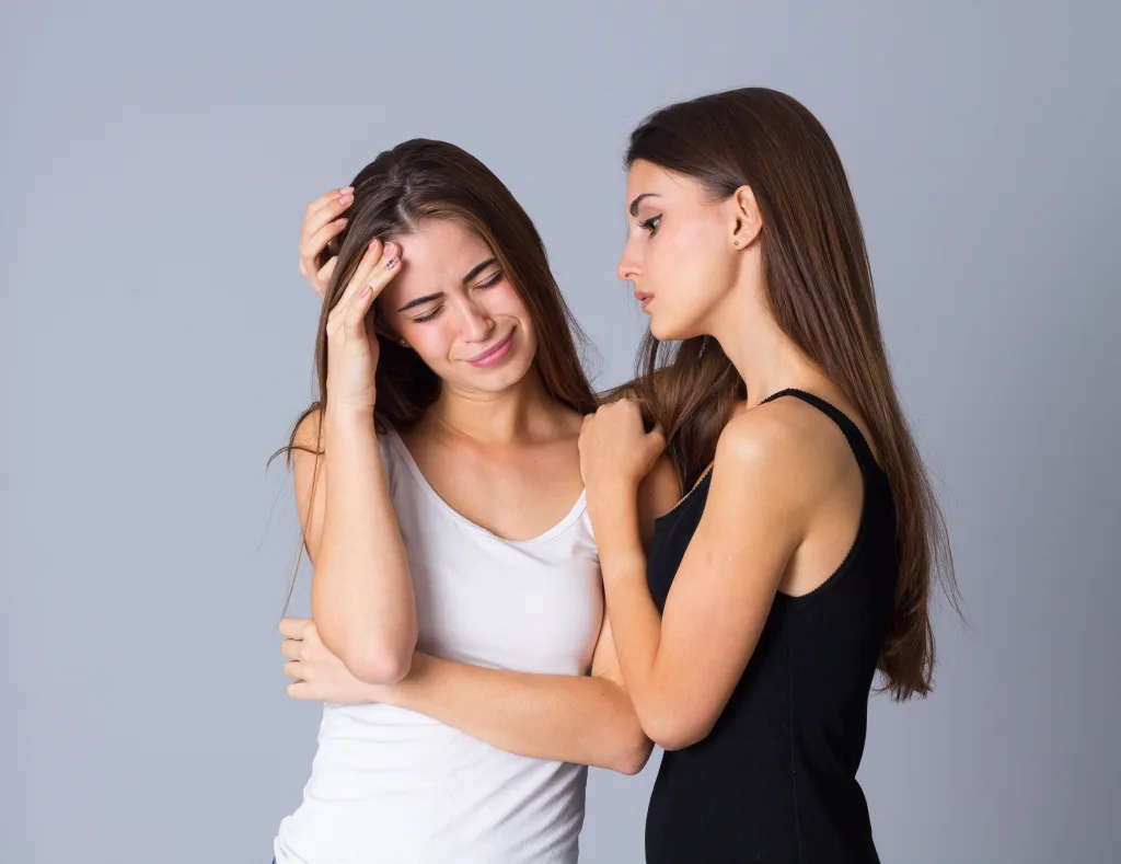 charming-woman-white-shirt-crying-woman-black-shirt-embracing-her-studio-min como superar un aborto