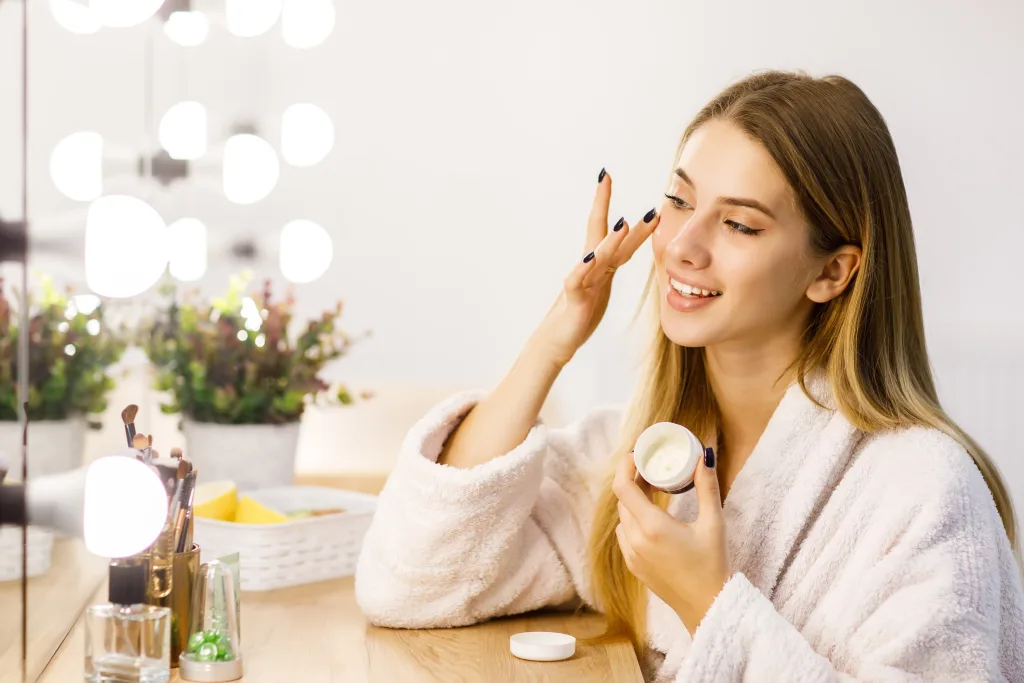 young-beautiful-blonde-girl-cares-face-skin-with-moisturizer-front-mirror-min disruptores endocrinos