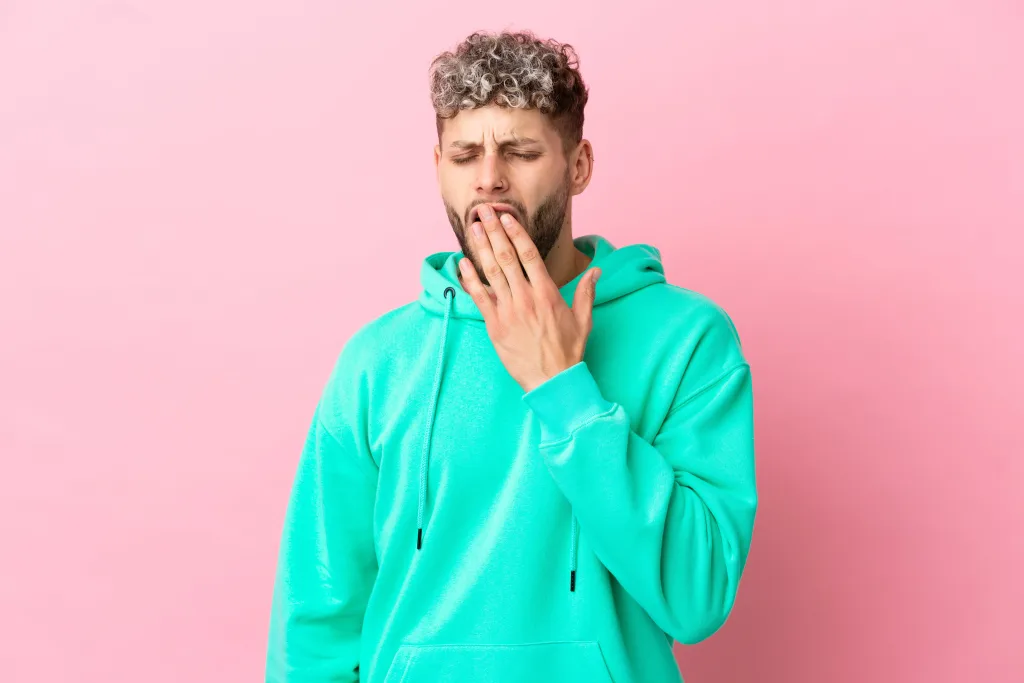 young-handsome-caucasian-man-isolated-pink-background-yawning-covering-wide-open-mouth-with-hand-min Cómo recuperar la flora intestinal después de tomar antibióticos